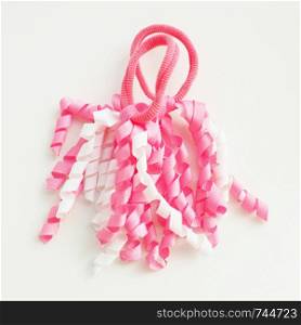Two funny baby hair bands in the form of white and pink spiral ribbons.