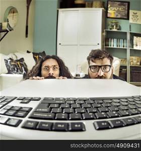 Two funny IT specialists staring at a keybord