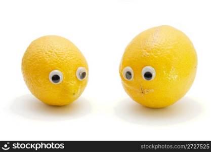 Two funny lemon fruits with eyes on white background