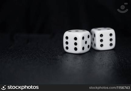Two gambling dices on a dark table