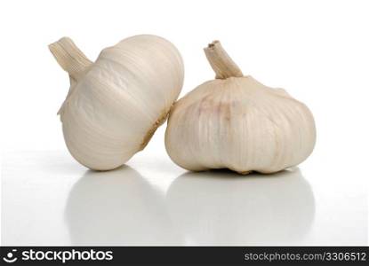 Two garlic on white background with shadow reflection.