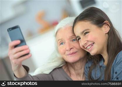 two generation women making a funny selfie together