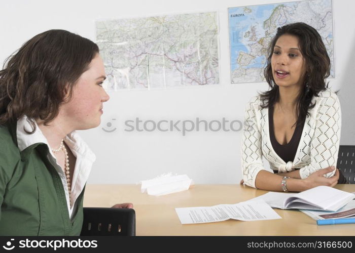 Two girl chatting away in schoolclass