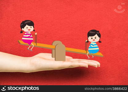 Two girl playing riding seesaw on hand