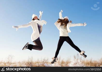 Two girlfriends have fun and enjoy fresh snow at beautiful winter day