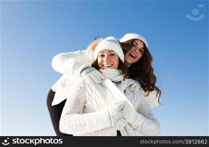 Two girlfriends have fun at beautiful winter day