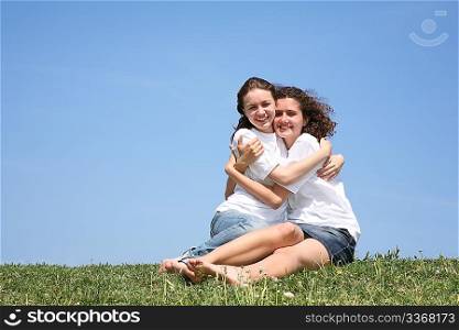 Two girlfriends in white T-shorts embrace