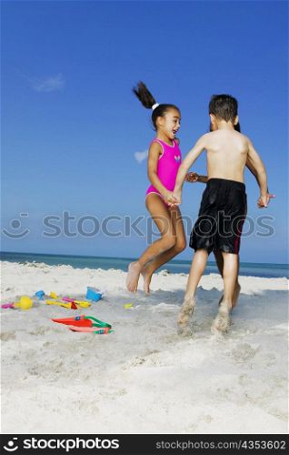 Two girls and a boy playing on the beach