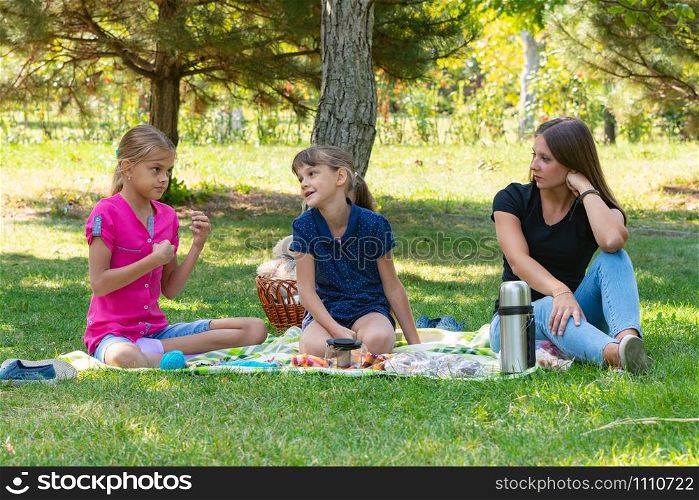 Two girls and a girl talking on a picnic