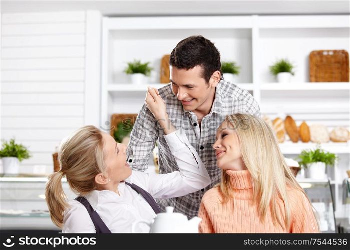 Two girls and the guy have fun in cafe