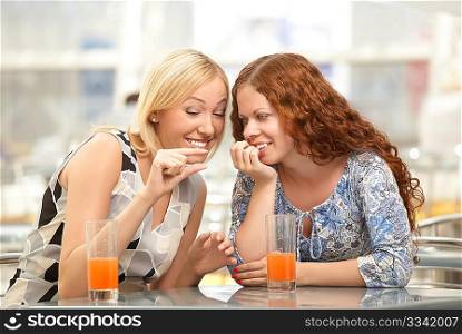 Two girls discuss men in a cafe