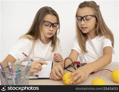 two girls doing science experiments with lemons