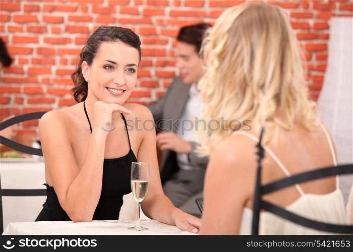 two girls dressed in robes talking in a restaurant
