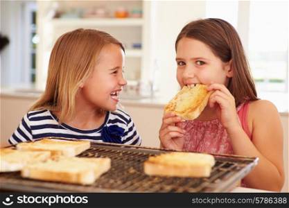 Two Girls Eating Cheese On Toast In Kitchen