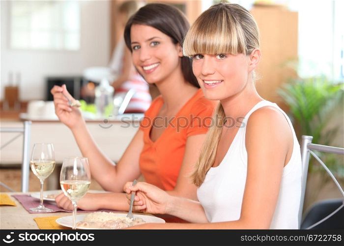Two girls eating in the kitchen