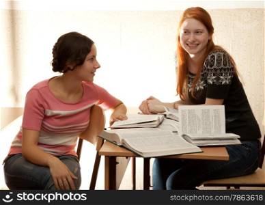 Two girls engage in a library in bright sunlight