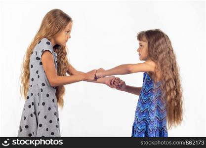 Two girls fight, grabbing each other's fists