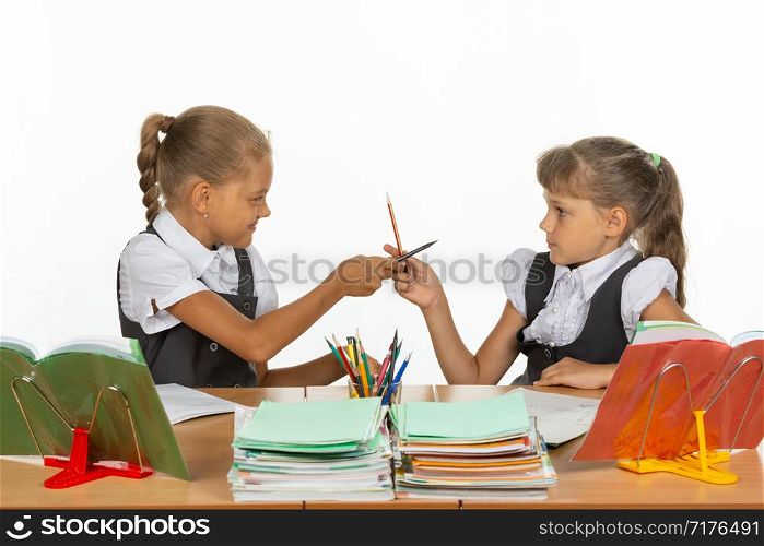 Two girls fight with pencils at a school desk