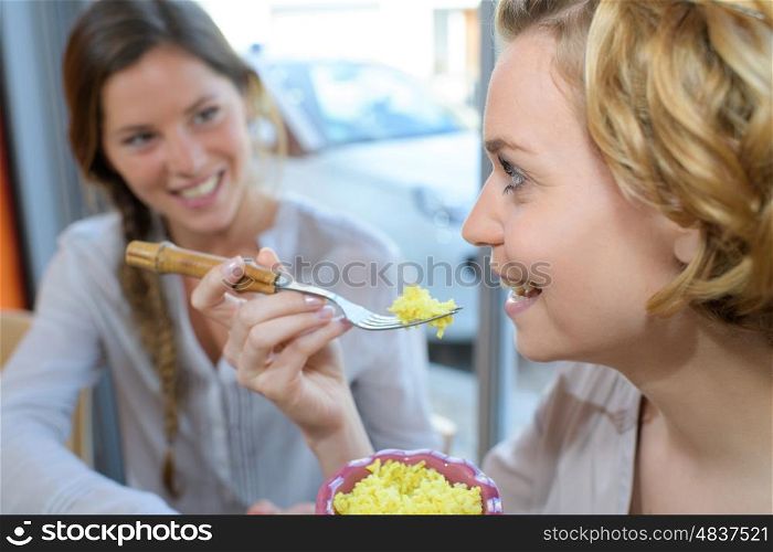 two girls having fun talking and eating in asian restaurant