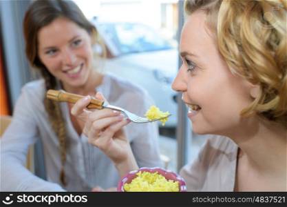 two girls having fun talking and eating in asian restaurant