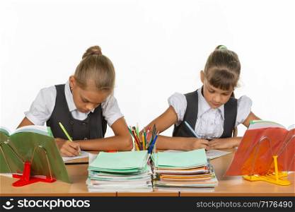 Two girls in a lesson write in a notebook