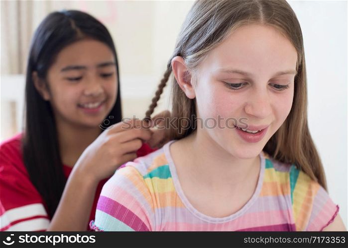 Two Girls In Bedroom Braiding Each Others Hair