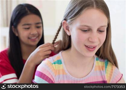 Two Girls In Bedroom Braiding Each Others Hair