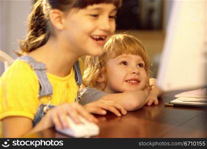 Two girls in front of a computer monitor