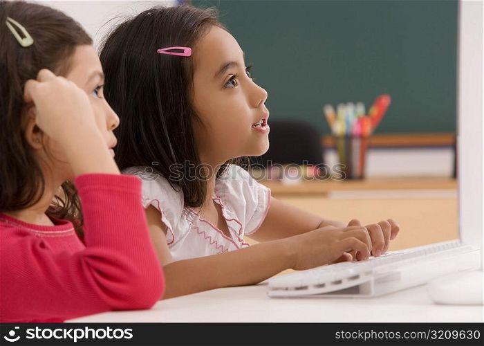 Two girls in front of a desktop PC in a classroom