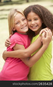 Two Girls In Park Giving Each Other Hug