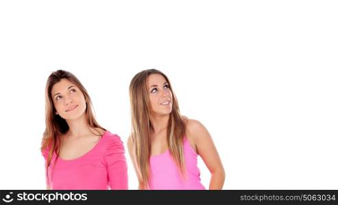 Two girls in pink looking up isolated on a white background