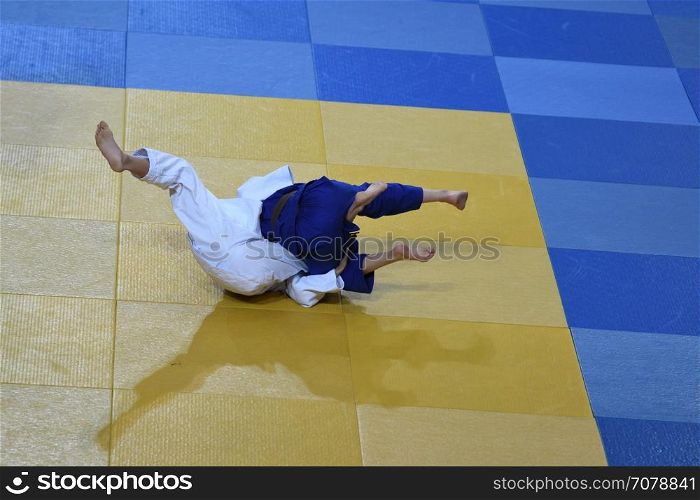 Two girls judoka in kimono compete on the tatami