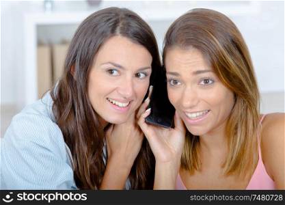 Two girls listening to cellphone