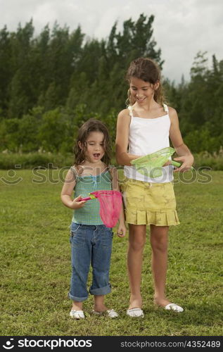 Two girls looking at a butterfly net