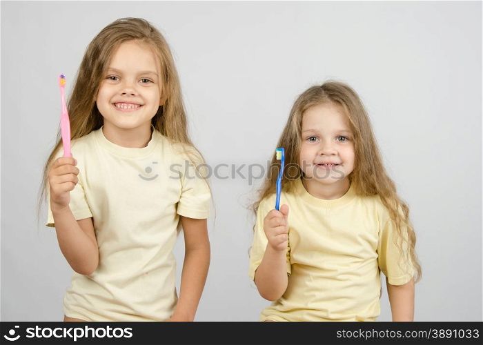 Two girls of four and six years of brushing their teeth toothbrushes. Two girls with toothbrushes