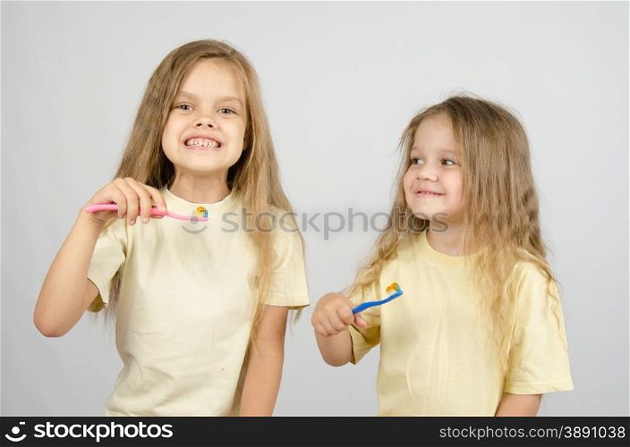 Two girls of four and six years of brushing their teeth toothbrushes. Two sisters with toothbrushes