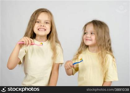 Two girls of four and six years of brushing their teeth toothbrushes. Two sisters with toothbrushes