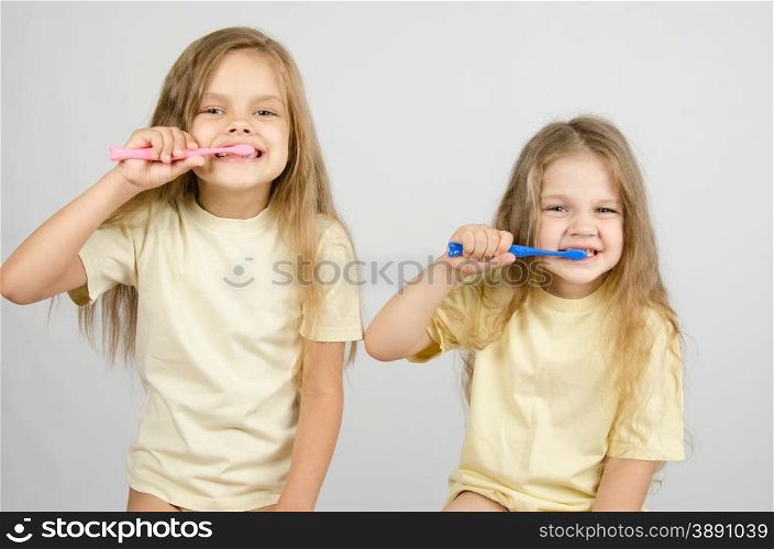 Two girls of four and six years of brushing their teeth toothbrushes. Two sisters brushing their teeth