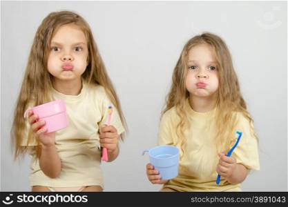 Two girls of four and six years of brushing their teeth toothbrushes. Two sisters Rinse your mouth brush your teeth