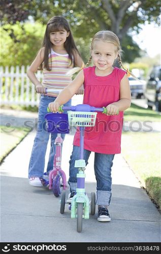 Two girls on scooters