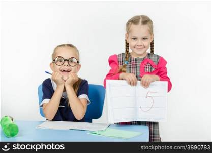 Two girls play school teacher and student. Happy schoolgirl received five