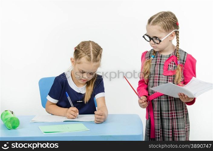 Two girls play school teacher and student. Privlezhnaya pupil under the supervision of a strict teacher