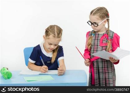 Two girls play school teacher and student. Privlezhnaya pupil under the supervision of a strict teacher