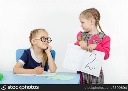 Two girls play school teacher and student. Schoolgirl with glasses again got a deuce