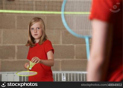 Two Girls Playing Badminton In School Gym