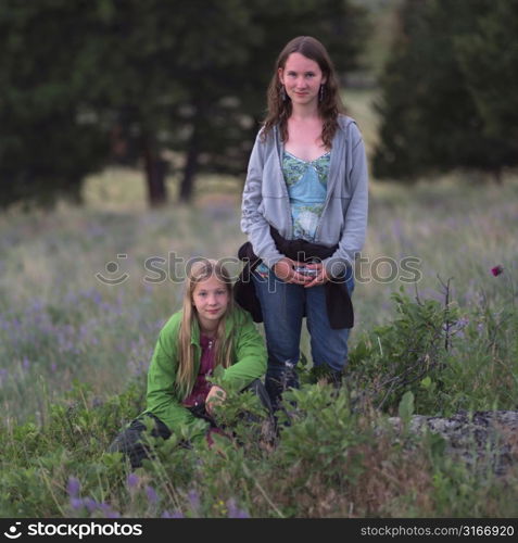 Two girls posing in field