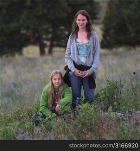 Two girls posing in field