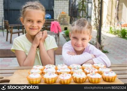 Two girls rejoice freshly baked Easter cupcakes