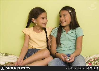 Two girls sharing headphones
