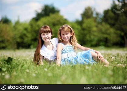 two girls spending time together in the summer park